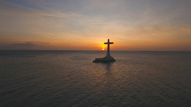 Aerial view Sunken Cemetery cross at sunset in Camiguin Island, Philippines. Large crucafix marking the underwater sunken cemetary of the coast of camiguin island near mindanao in the Philippines