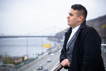 Portrait of an young happy plus size handsome European or American businessman.  businessman wearing suit, rest at city center, planning future project. 