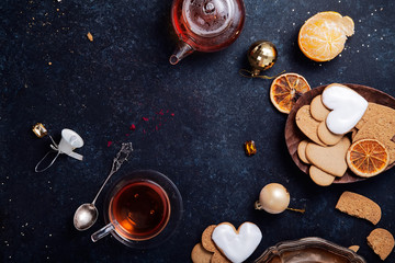 Fototapeta na wymiar Teatime with heart-shaped ginger cookies and tangerines. Christmas background with festive decoration. Horizontal composition