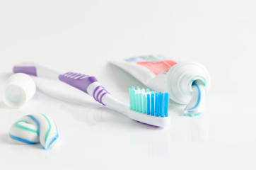 A tube of toothpaste and a toothbrush on white background