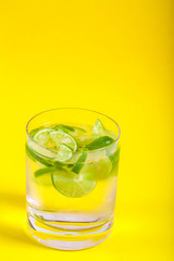 Glass with Water on Yellow Background