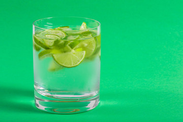 Glass with Water on Green Background