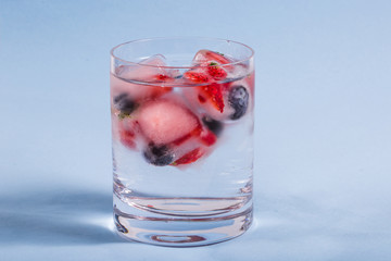 Ice berries in glass of water
