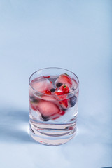Ice berries in glass of water