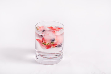 Ice berries in glass of water