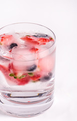 Ice berries in glass of water
