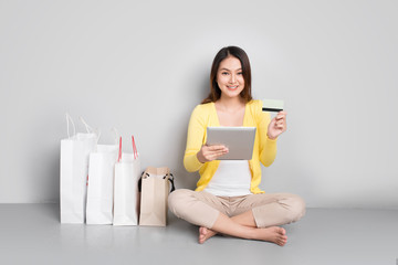 Beautiful asian girl shopping online using credit card