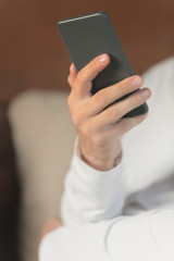Man sitting on a sofa and using cellphone.