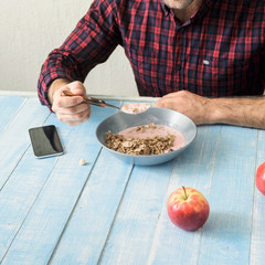 Man eating healthy breakfast in the kitchen at home