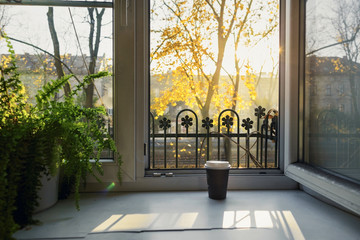 Cup of coffee on the windowsill at an open window