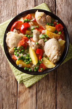Chicken meat stewed with vegetables and spices close-up in a bowl. Vertical top view