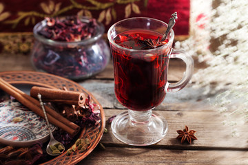 Mulled wine with a badge and cardamom in a glass on a wooden table top