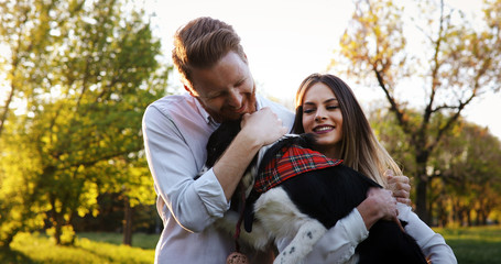 Fototapeta premium Beautiful couple cuddling and walking dogs outdoors
