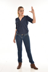 full length portrait of air wearing blue shirt and denim pants, standing pose on white background.