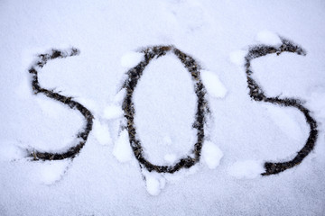 SOS sign for help needed written in the snow