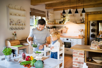 Young father with a toddler boy cooking.