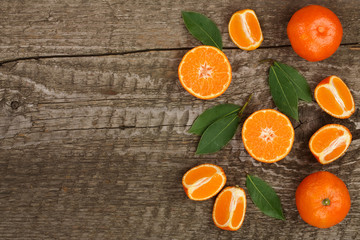 orange or tangerine with leaves on old wooden background. Flat lay, top view. Fruit composition