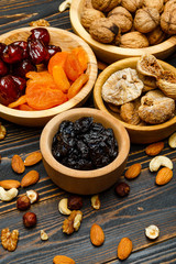 dried fruits figs, apricots, plums and nuts on wooden background