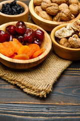 dried fruits figs, apricots, plums and nuts on wooden background