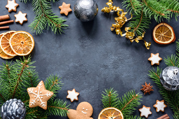 Christmas or New Year frame with fir tree branches, gingerbread cookies, spices, dried orange rings...