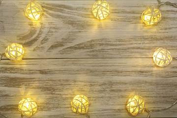 christmas garland lights on old wooden background with copy space for your text. Top view