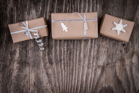 Gift boxes package decorated for Christmas or New Year on rustic wooden background and space for text