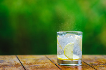 A glass of water. Lemon. Cocktail straw.