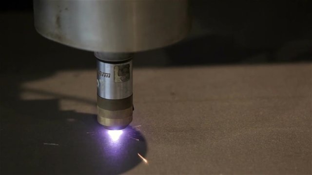 Close up laser cutter cutting line in steel