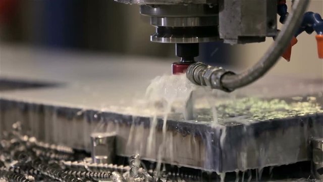 Machine drilling a hole in a steel plate at high pressure