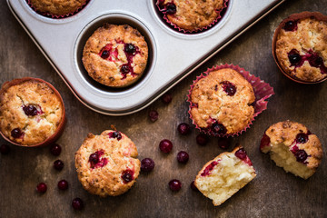 cupcake baking with cranberries on wooden background