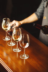 Glasses of white and red wine on wooden bar counter