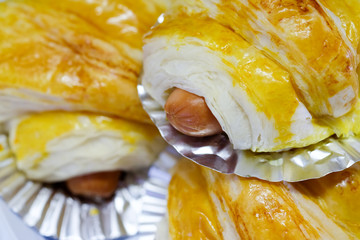 Close up baked bread put sausage on a foil