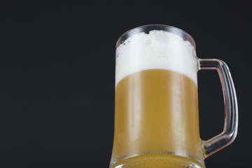 Light beer in a mug on a dark background