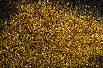 Sprinkle glitter gold dust in the dark textured abstract background elegant for Merry christmas and Happy new year