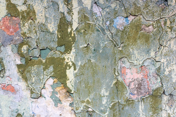 Tatter of a multi-colored old paint on a surface of a stone wall