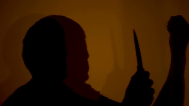 Shadow of masochist cutting skin on arms and enjoying pain, mental disorders