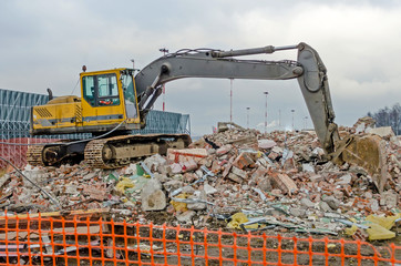 Excavator working at the demolition of an old industrial building.