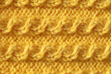 The texture of the knitted product is yellow. Background of fluffy fibers from woolen threads.