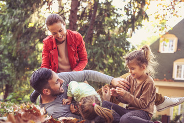 Lets tickling together a father. Happy family playing outside.