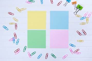 note paper and note book with paper clips on white wooden background