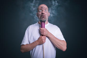 Mann mit lila explodierter Silvester Rakete macht dummes Gesicht