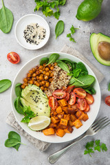 healhty vegan lunch bowl. Avocado, quinoa, sweet potato, tomato, spinach and chickpeas vegetables...