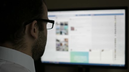 A man using on social networks. Businessman reads the news. Computer monitor showing blur Facebook news feed page young girl online. - Powered by Adobe