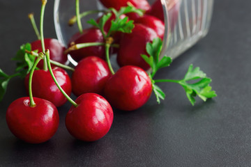 Close up fresh cherries on black granite table in side view with copy space for background or...