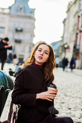 Obraz premium Brunette woman with long hair drinks coffee at the table