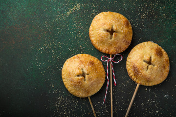 apple pie pops on dark green background.