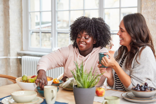 Zwei Frauen essen gemeinsam Frühstück in WG Küche