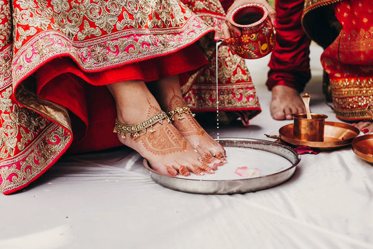 People pour coconut milk on Hindu bride's feet during the wedding ceremony  Saptapadi Stock Photo | Adobe Stock