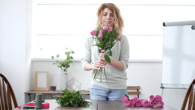 Woman florist makes flower bouquet