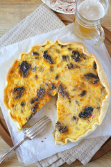 Onion and prunes quiche and mug of beer. Top view